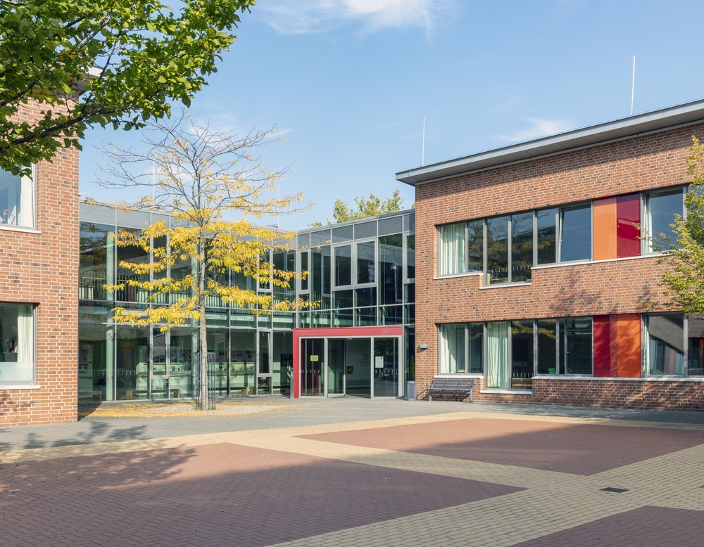 Münster, Regenbogenschule, Ansicht eines Schulgebäudes mit Pausenhof im Vordergrund
Bild: PODEHL Fotodesign